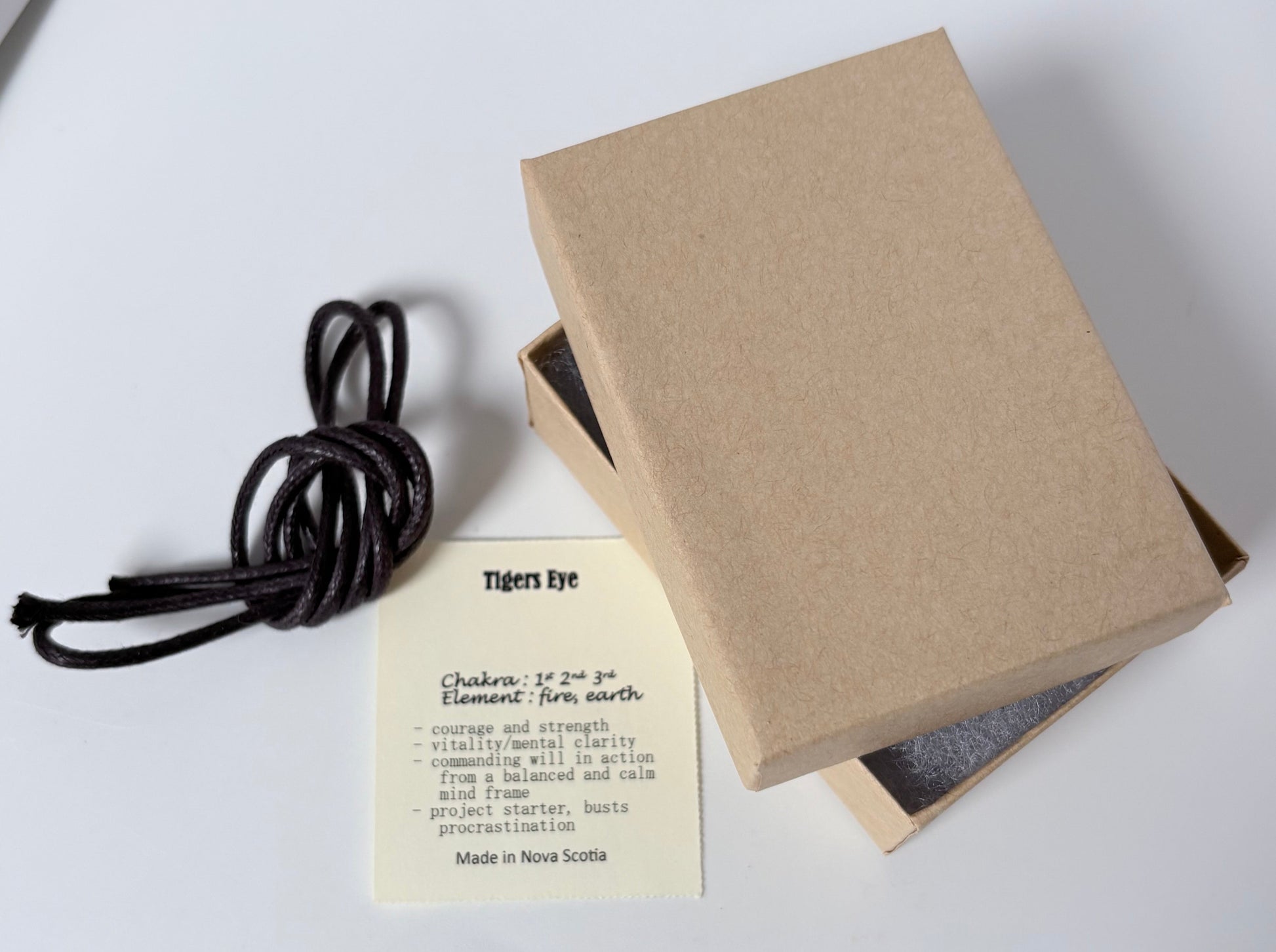 Dark brown cord to wear pendant, kraft colour jewelry box packaging, spiritual information card about tigers eye pendant on a white background 