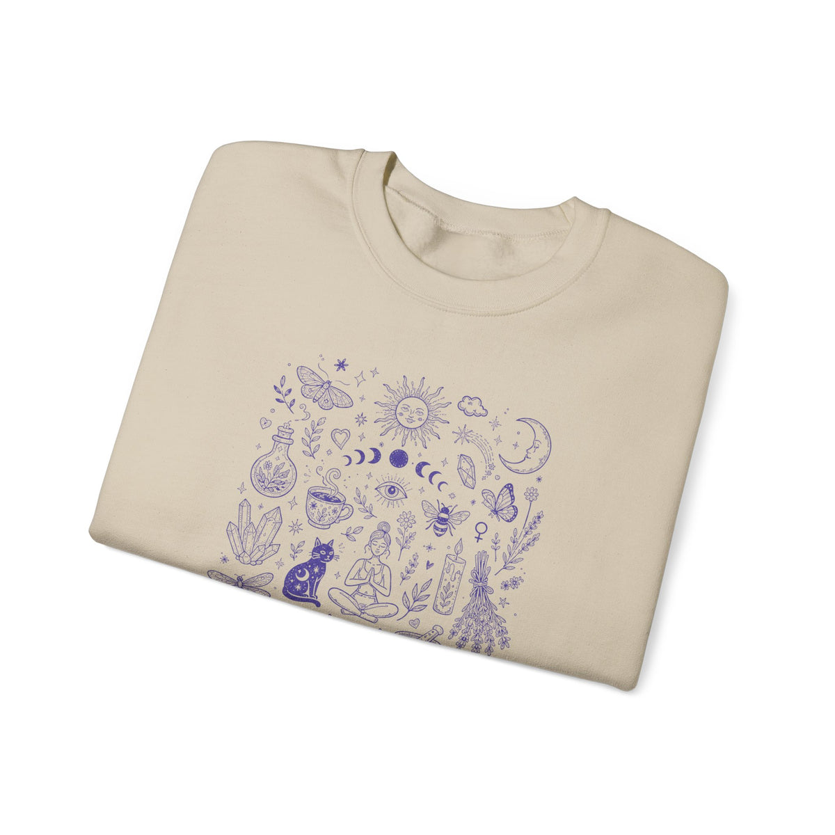 A folded beige crewneck sweatshirt featuring a vertical doodle graphic print of various purple mystical and celestial illustrations, including moons, stars, crystals, tarot, and a cat, displayed on a clean white background.