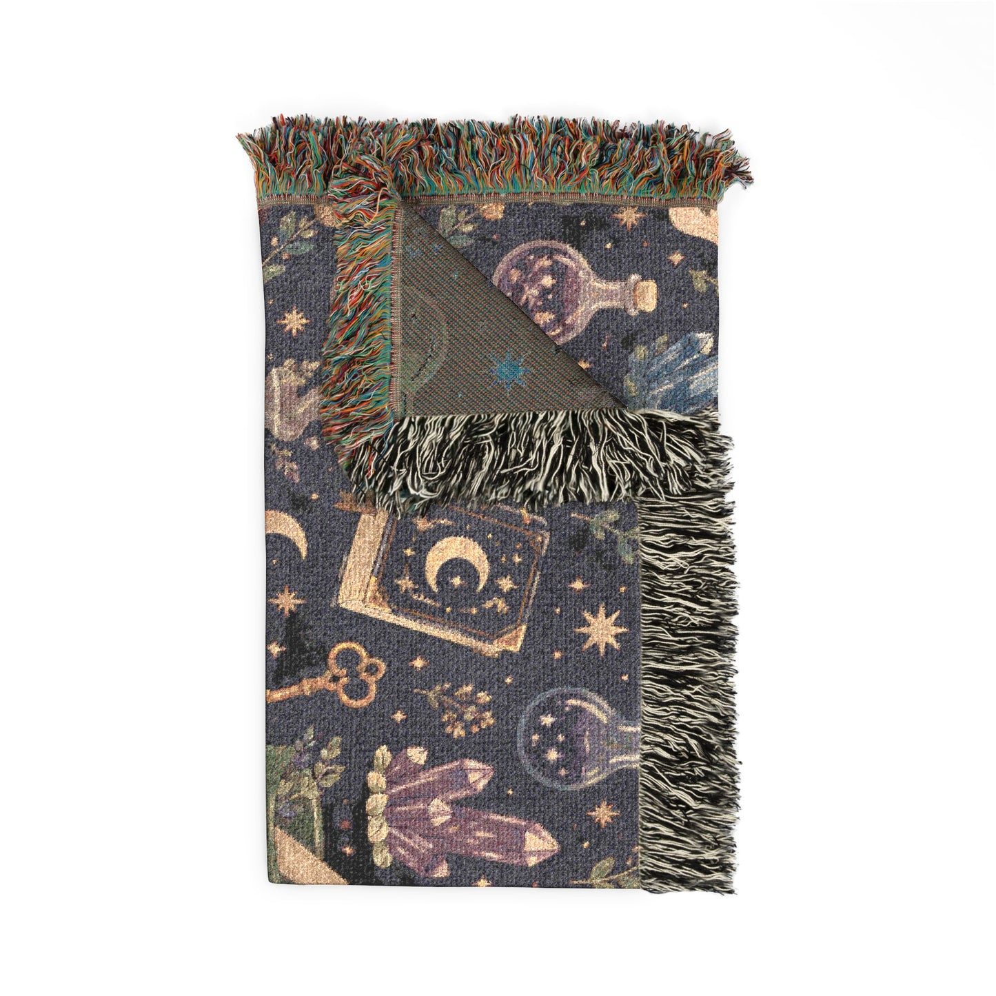 Folded Medium-Large sized witchy woven blanket with fringed edges, featuring an apothecary pattern with crystals, moons, potion bottles, spell books and stars. 50"x60"