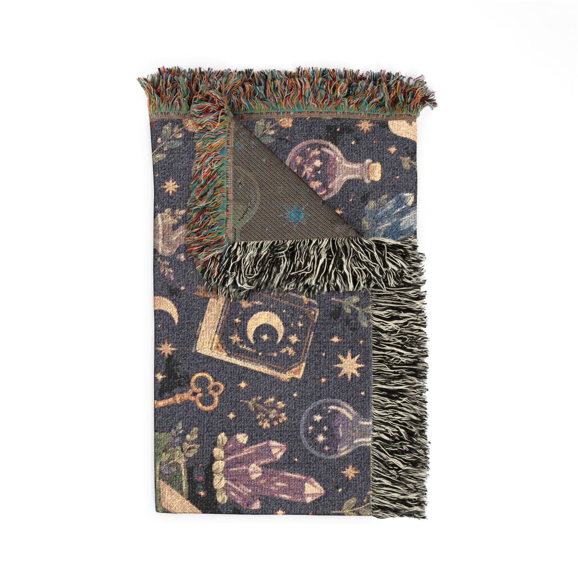 Folded Medium-Large sized witchy woven blanket with fringed edges, featuring an apothecary pattern with crystals, moons, potion bottles, spell books and stars. 50"x60"