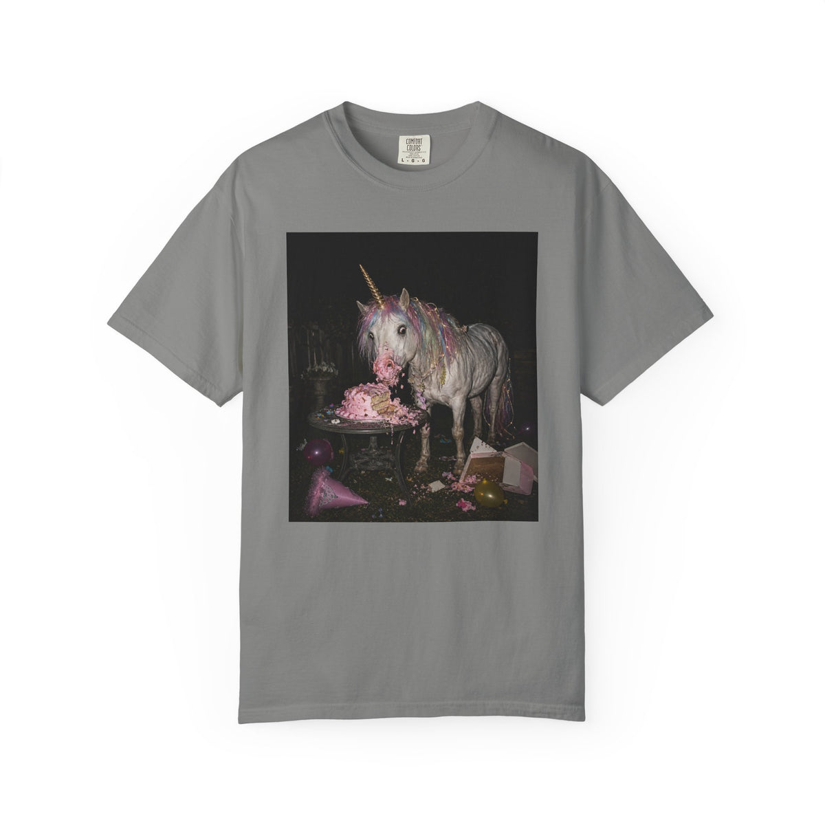 Grey graphic t-shirt with a retro-style photo of a unicorn stealing pink birthday cake at a dark party scene, shown on a white background.