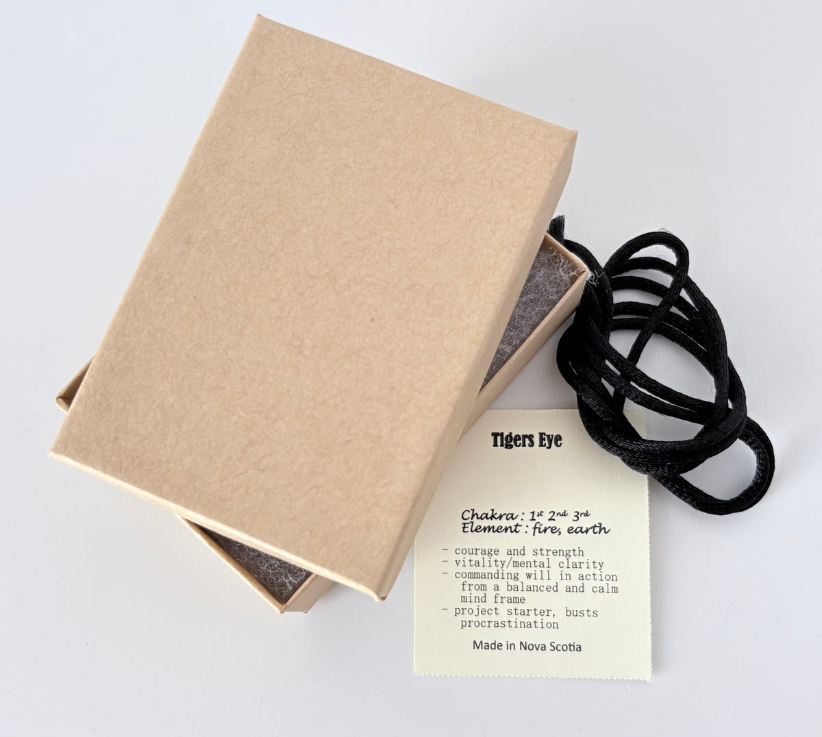 Kraft paper jewelry box with a tigers eye information tag and cream colour cord for a pendant on a white background