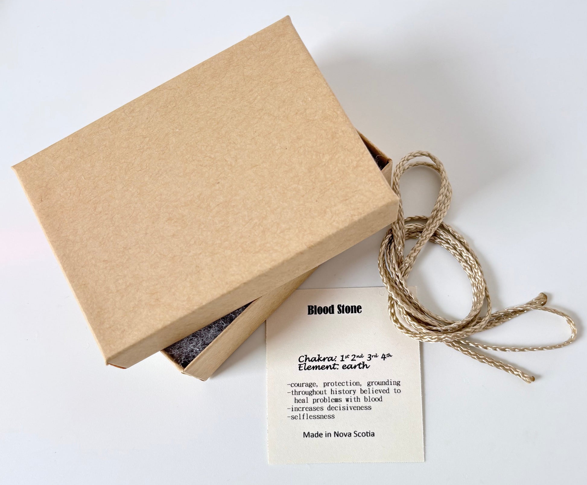 Kraft paper jewelry box with a bloodstone information tag and cream colour cord for a pendant on a white background