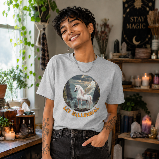 Person wearing a grey t-shirt with a graphic design of a flying unicorn and text "Lit Millennial", standing in a room with plants and decor.